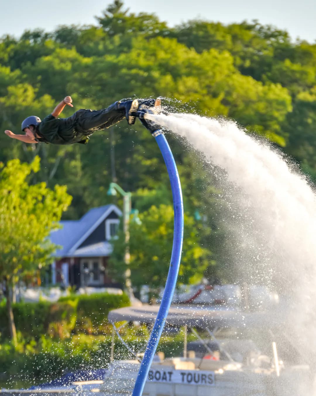 Advanced Flyboard rider extending horizontally above a Muskoka waterfront