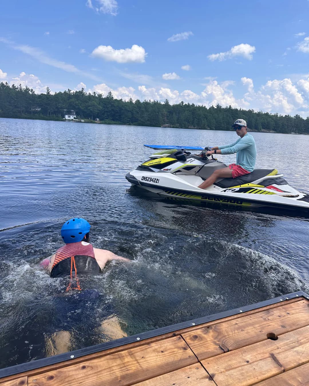 Participant in the water beside a dock while an instructor operates a Sea-Doo