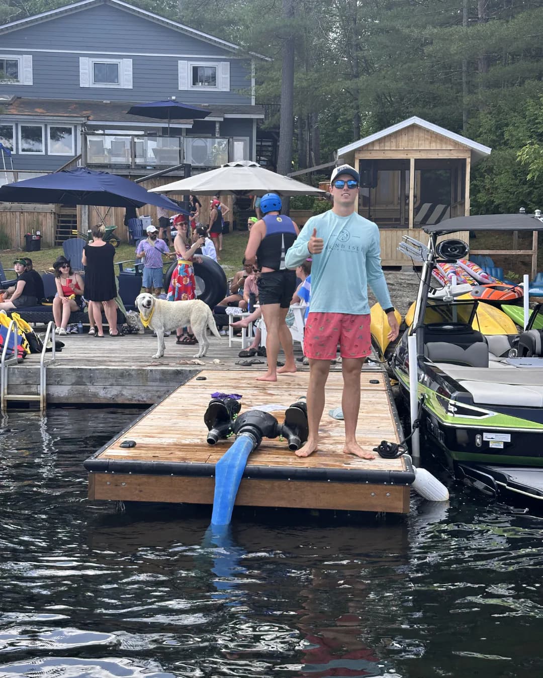 Group gathered on a cottage dock beside Flyboard equipment and Sea-Doos