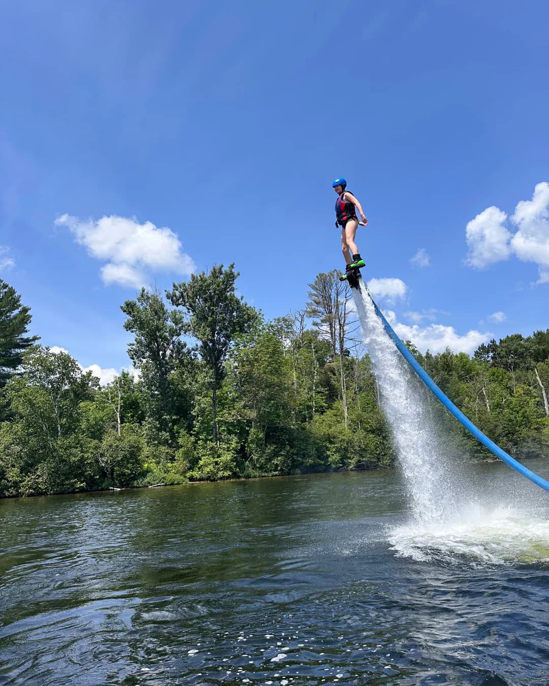 Rider flying independently above a forested Ontario lake