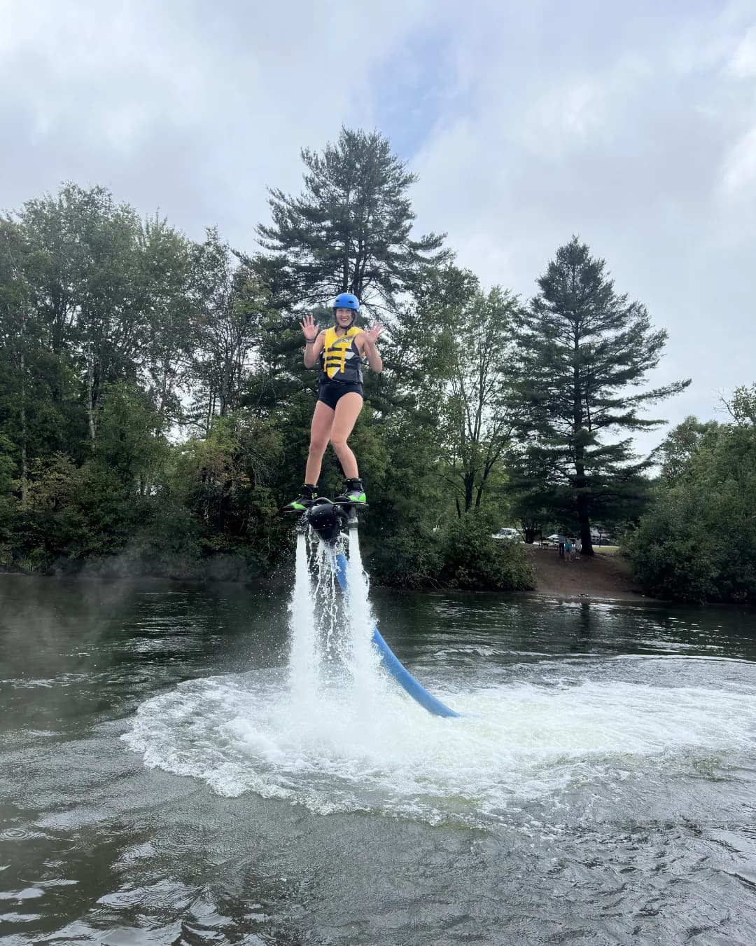 Helmeted rider learning to Flyboard above the water at Lake Muskoka